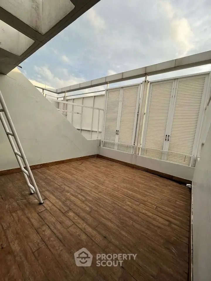 Spacious rooftop terrace with wooden flooring and modern design.