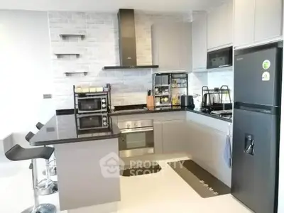 Modern kitchen with sleek appliances and stylish black countertops.