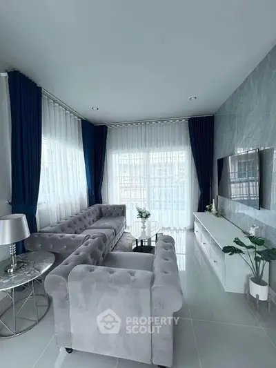Elegant living room with plush sofas and modern decor in a bright, airy space.