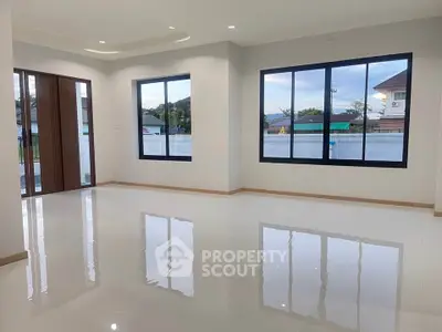 Spacious modern living room with large windows and glossy tile flooring