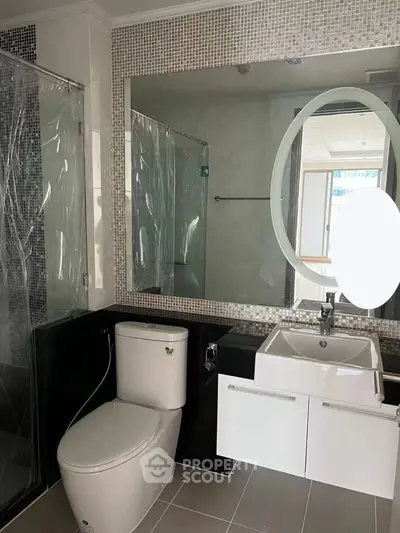 Modern bathroom with sleek fixtures and large mirror in a contemporary home.