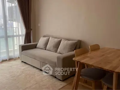 Cozy living room with a comfortable sofa and dining table, perfect for relaxation and dining.