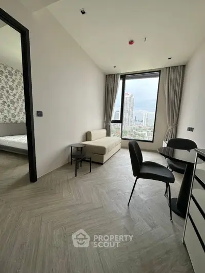 Modern living room with city view, featuring sleek furniture and large windows for natural light.