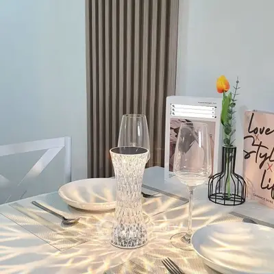 Elegant dining setup with crystal vase and wine glasses on a stylish table.