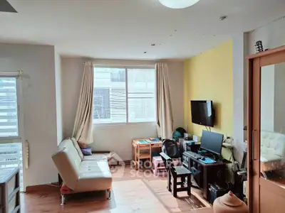 Bright living room with modern furniture and large windows in a cozy apartment.