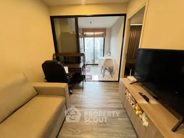 Cozy living room with modern decor and balcony view, perfect for urban living.