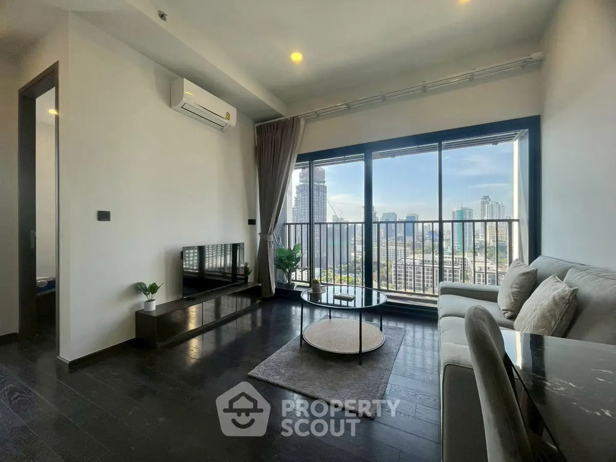 Modern living room with city view, sleek furniture, and large windows in a high-rise apartment.