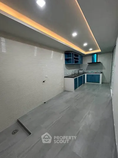 Modern kitchen with sleek design, featuring blue cabinets and recessed lighting, perfect for culinary enthusiasts.