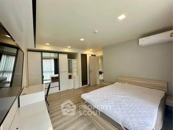 Spacious modern bedroom with stylish decor and ample natural light