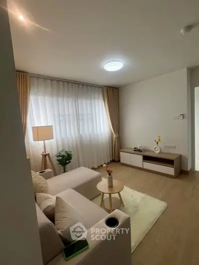 Modern living room with cozy seating and natural light, perfect for relaxation.