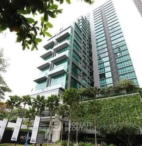Modern high-rise building with lush greenery and sleek architectural design.