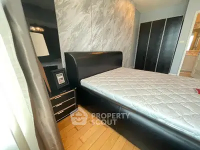 Modern bedroom with sleek black leather bed and stylish decor
