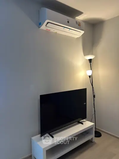 Modern living room with sleek TV setup and efficient air conditioning unit.