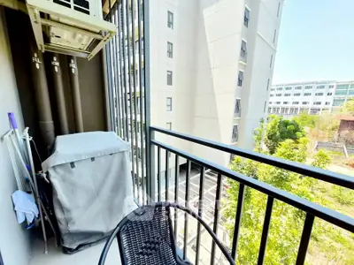Modern balcony with city view, featuring outdoor seating and air conditioning unit.
