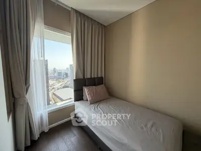 Cozy bedroom with a single bed and city view, perfect for urban living.