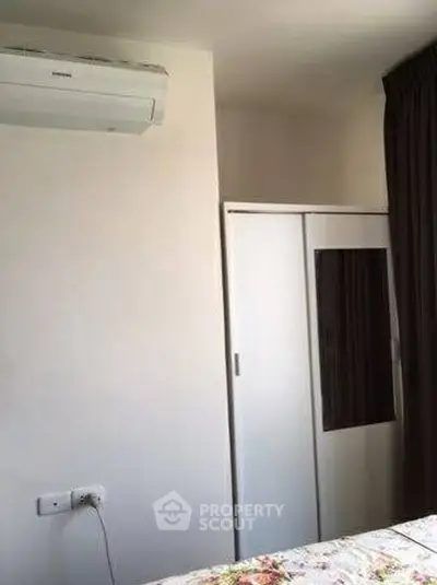 Cozy bedroom with air conditioning and wardrobe