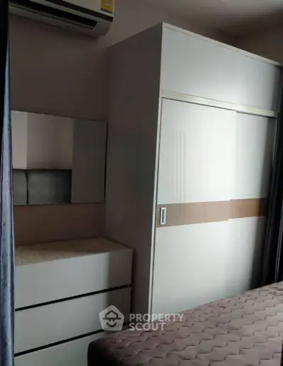 Modern bedroom with sleek wardrobe and air conditioning, perfect for comfortable living.