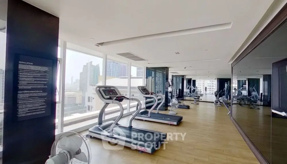 Spacious modern gym with city view and state-of-the-art equipment.