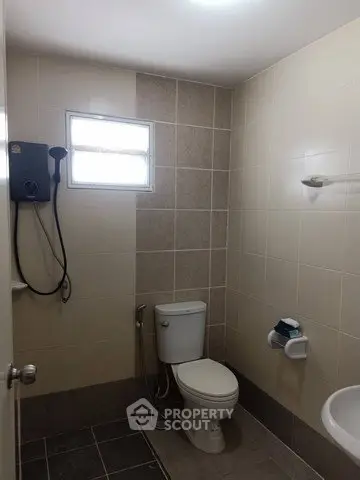Modern bathroom with tiled walls and shower in a real estate property.