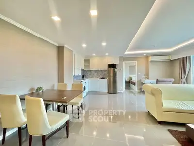 Spacious open-plan living room and kitchen with modern furnishings and ample natural light.