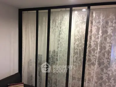 Stylish living room with elegant lace curtains and modern sliding glass doors.
