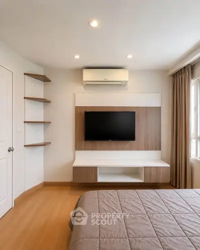 Modern bedroom with wall-mounted TV and air conditioning, featuring sleek wooden shelves and natural light.