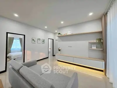 Modern living room with sleek design and neutral tones, featuring a cozy gray sofa and stylish shelving.