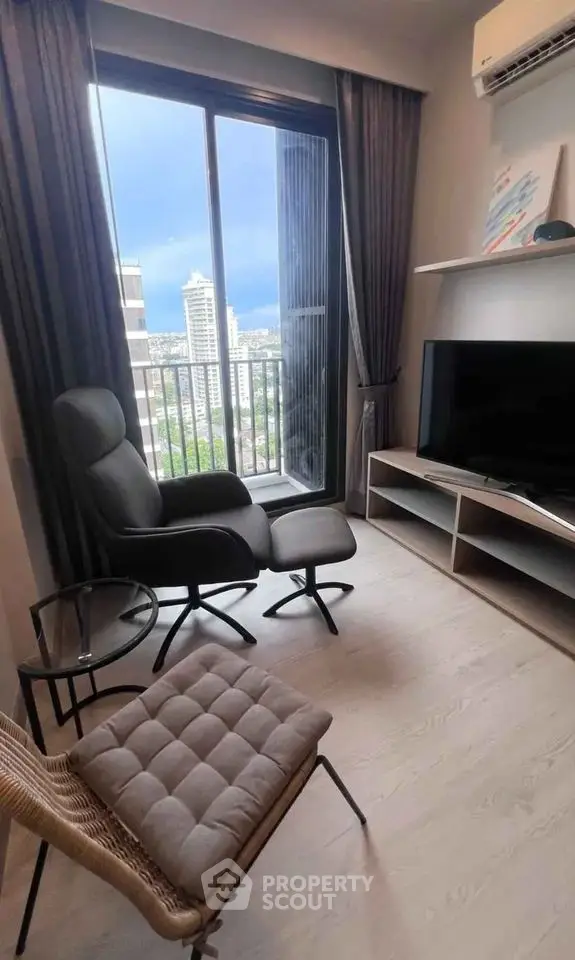 Modern living room with city view, stylish furniture, and large window in high-rise apartment.
