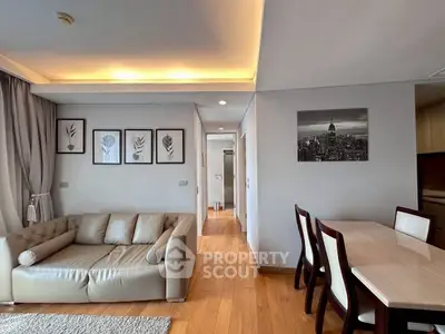 Modern living room with elegant decor and dining area, featuring stylish artwork and cozy seating.