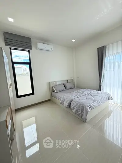 Modern bedroom with sleek design, featuring a comfortable bed, large window, and air conditioning unit.