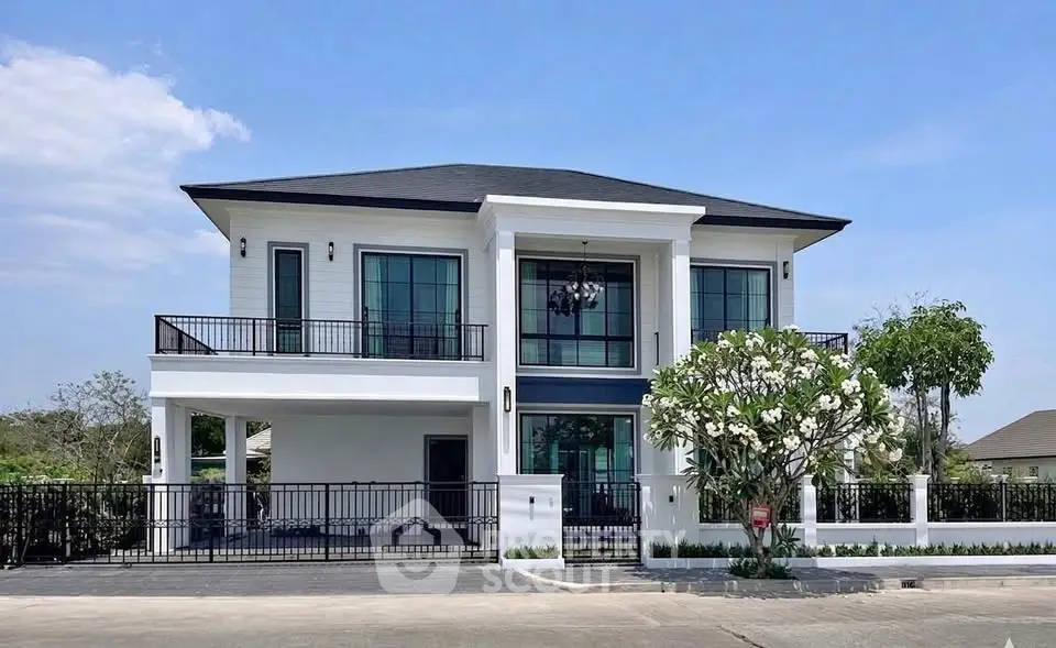 Stunning modern two-story house with large windows and spacious balcony, perfect for luxurious living.