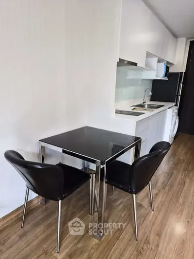 Modern kitchen with sleek dining area and wooden flooring in a stylish apartment.