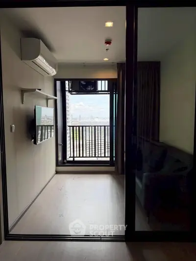 Modern apartment with balcony and city view, featuring sleek interior design and air conditioning.
