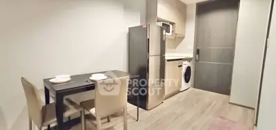 Modern kitchen with dining area, featuring stainless steel appliances and sleek design.