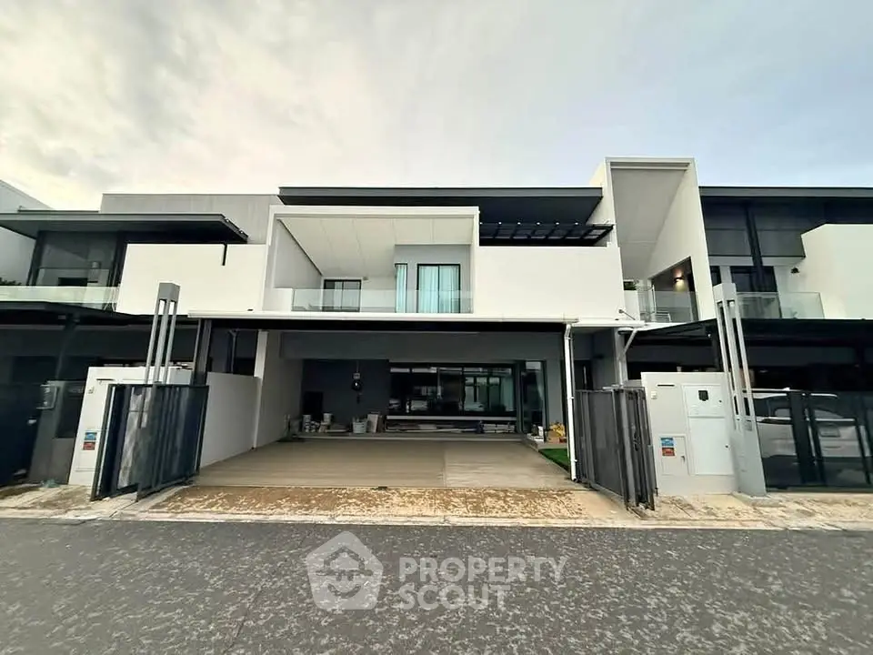 Modern luxury townhouse with sleek architecture and spacious driveway in upscale neighborhood.