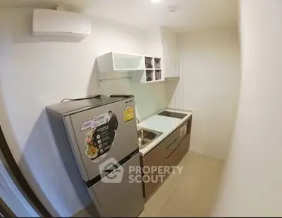 Modern compact kitchen with sleek appliances and stylish cabinetry in a cozy apartment.