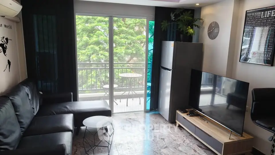 Modern living room with sleek furniture and balcony view, featuring a large TV and stylish decor.