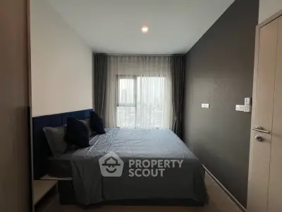 Modern bedroom with city view, featuring sleek design and ample natural light.