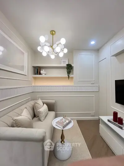 Elegant living room with modern chandelier and cozy sofa in a stylishly decorated apartment.