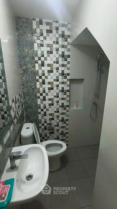 Modern bathroom with stylish tile design and compact layout.