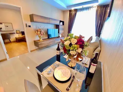 Elegant living room with modern decor and dining setup, featuring a cozy ambiance and stylish furnishings.