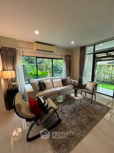 Elegant living room with garden view, modern furniture, and cozy ambiance.