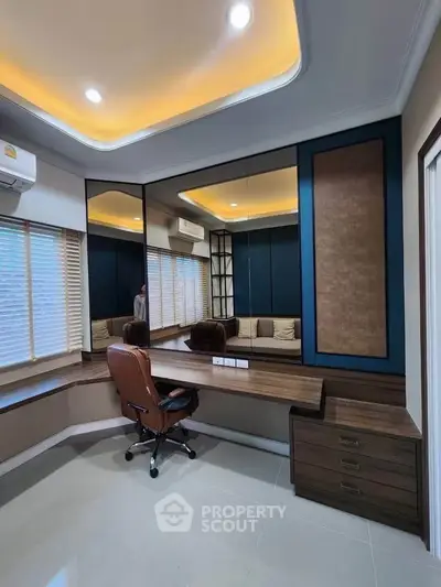 Modern study room with elegant desk and chair, featuring stylish lighting and large mirrors.