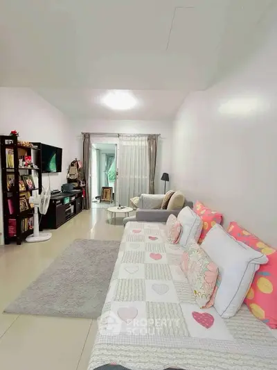 Spacious living room with cozy decor and ample natural light, perfect for relaxation and entertainment.
