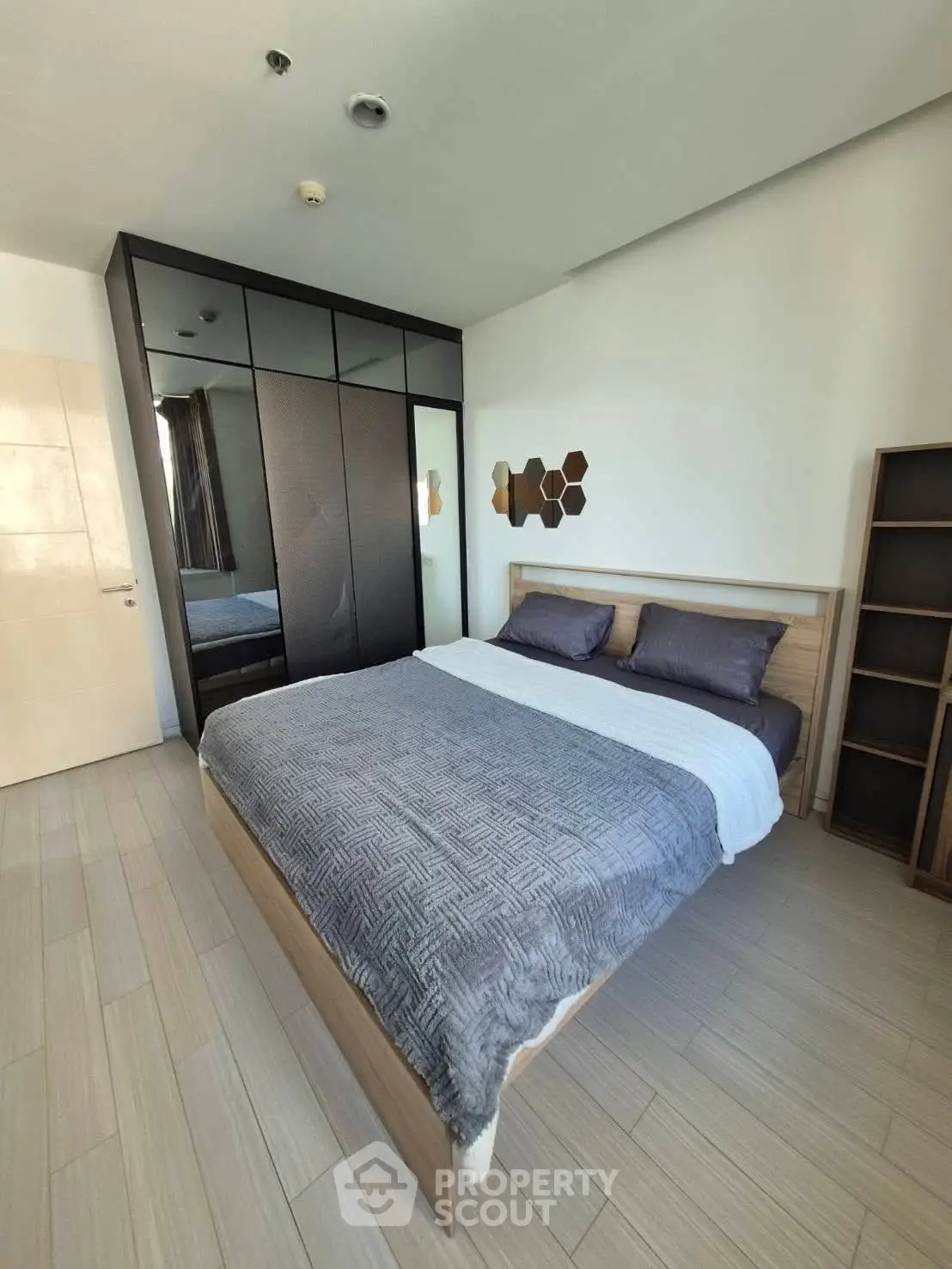 Modern bedroom with sleek wardrobe and stylish decor in a contemporary apartment.