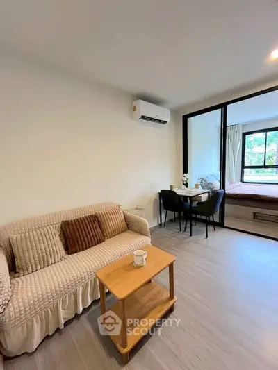 Modern living room with cozy sofa and dining area in open-plan apartment