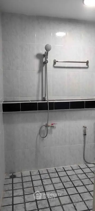 Spacious bathroom with modern shower and tiled walls, perfect for a relaxing experience.