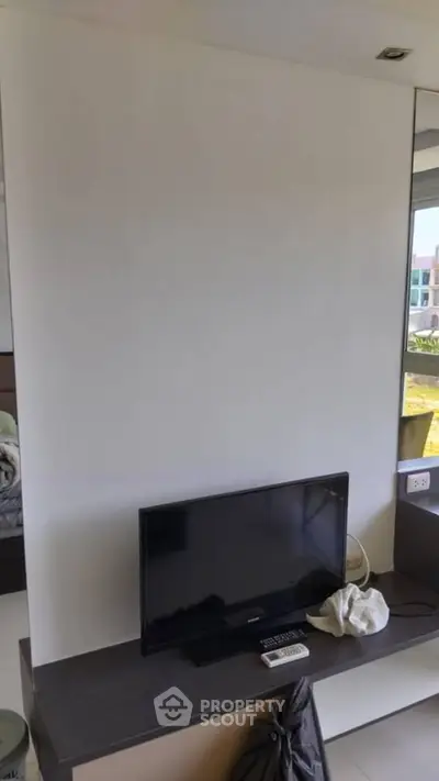 Modern living room with sleek TV setup and large window view