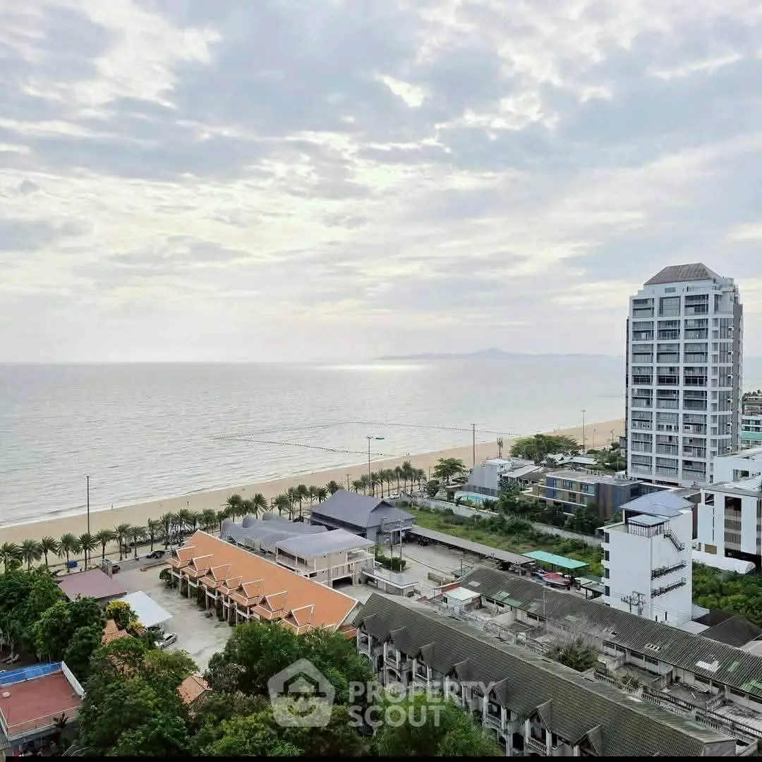 Stunning beachfront view with modern high-rise and lush greenery, perfect for luxury living.
