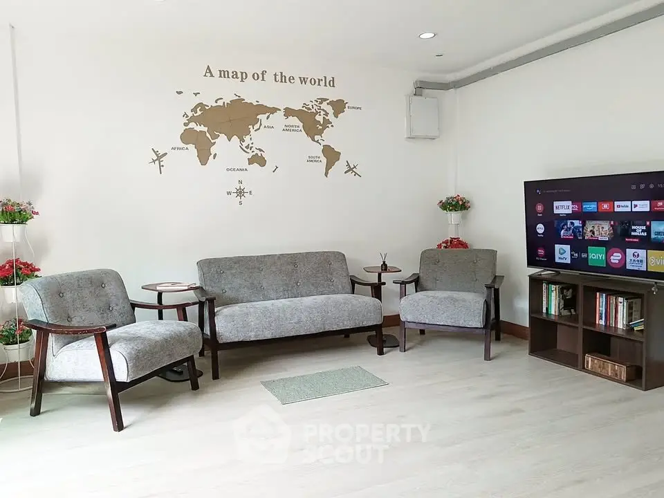 Modern living room with world map decor and smart TV, perfect for relaxation.